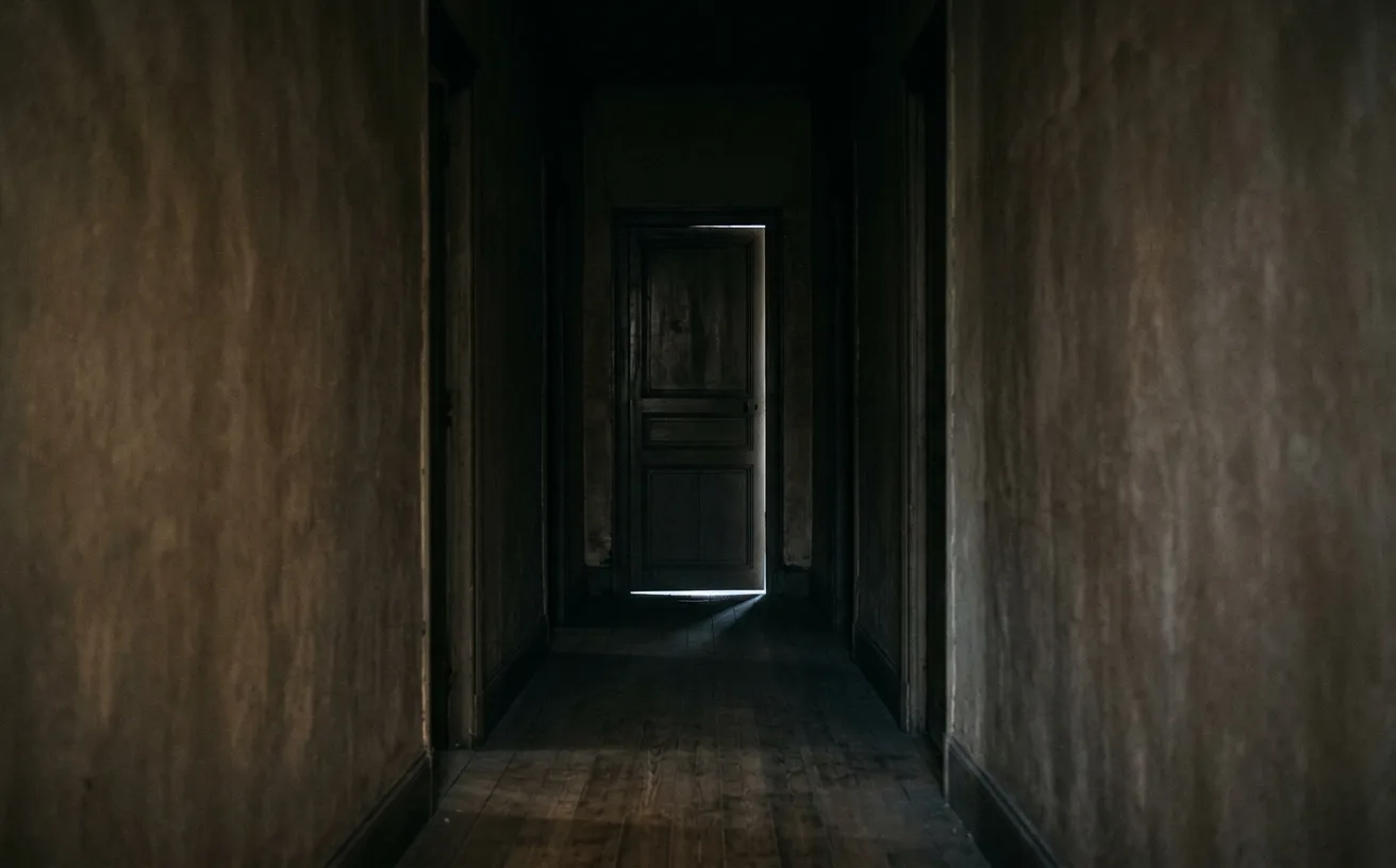 Porte fermée au bout d'un couloir sombre, symbole d'attendre un changement qui ne vient pas